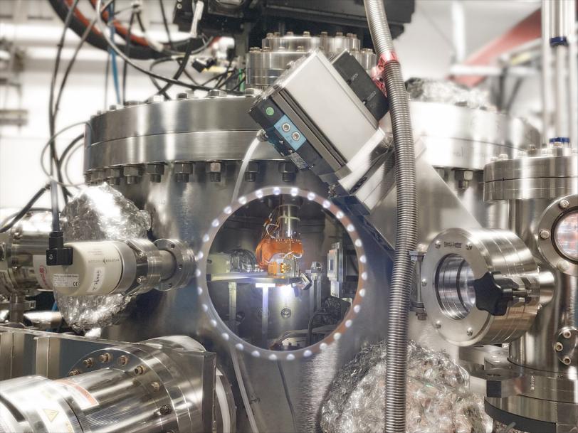A small copper apparatus sits inside a larger metal cylinder.